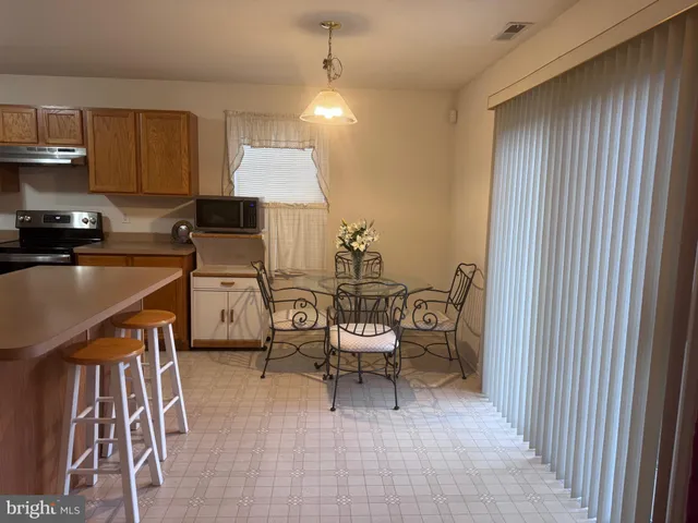 a kitchen with table chairs refrigerator and cabinets