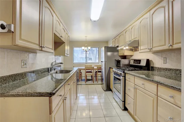 a kitchen with stainless steel appliances granite countertop a sink stove and cabinets