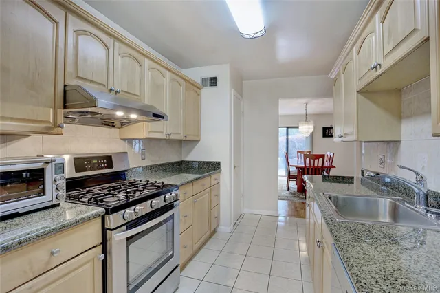 a kitchen with stainless steel appliances granite countertop a sink stove and cabinets