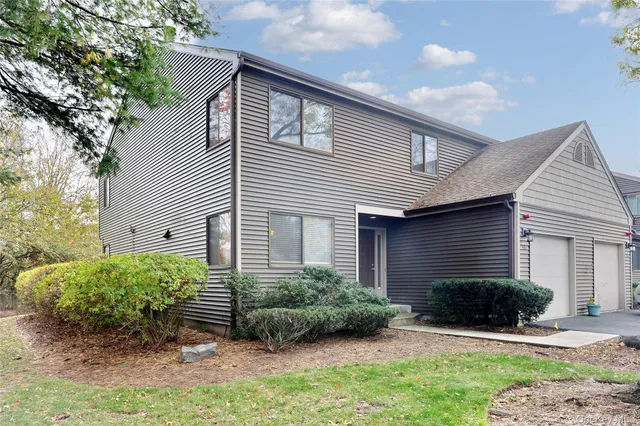 a front view of a house with a yard and plants