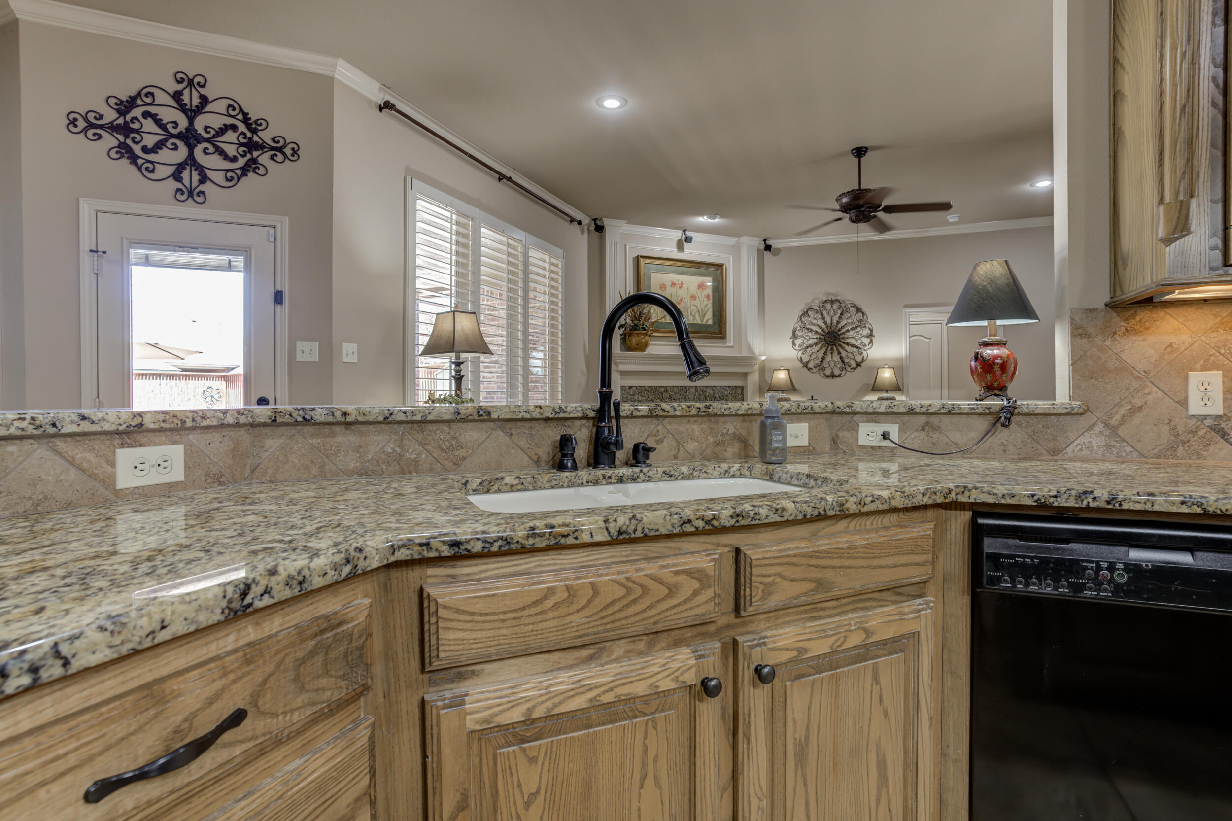 6008 89th Street Lubbock, TX 79424 - Photo 20 of 61 a kitchen with granite countertop a sink stainless steel appliances white cabinets and a granite counter tops
