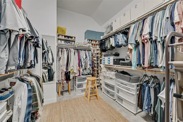 a view of walk in closet with clothes and shoes