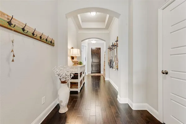 a hallway with wooden floor table and chairs