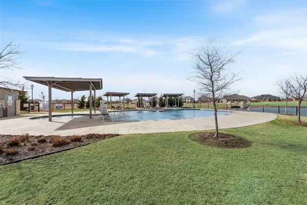 a swimming pool with lots of green space and palm trees