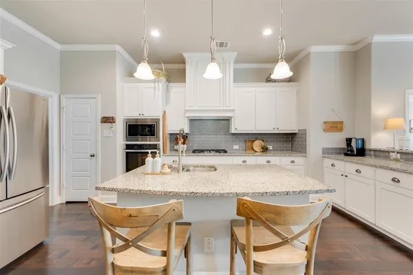a large kitchen with a table chairs refrigerator and microwave