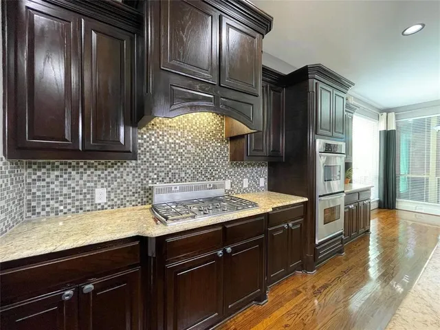 a kitchen with stainless steel appliances granite countertop cabinets and wooden floor