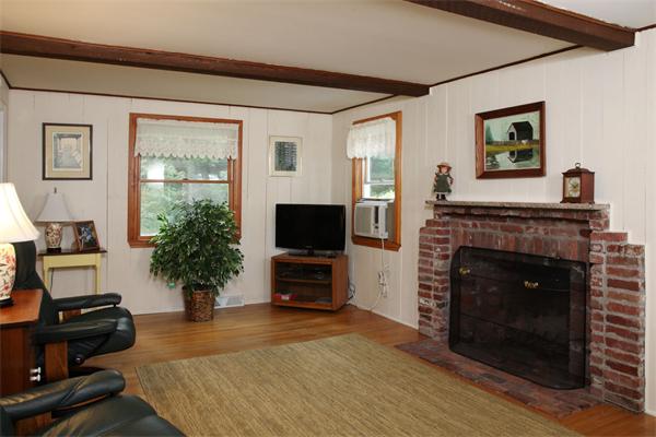 85 Oxbow Road Wayland, MA 01778 - Photo 4 of 8 a living room with furniture a flat screen tv and a fireplace