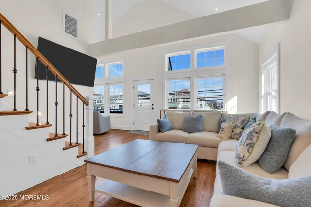 a kitchen with stainless steel appliances granite countertop a stove a sink dishwasher a dining table and chairs with wooden floor