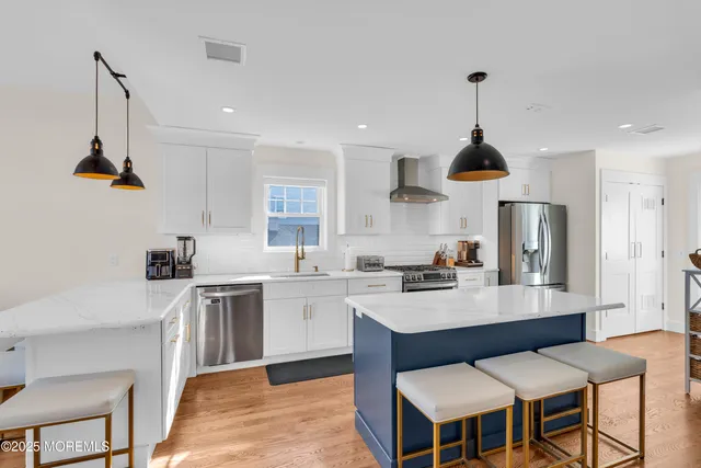 a kitchen with stainless steel appliances granite countertop a sink a stove and white cabinets