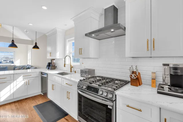 a large kitchen with stainless steel appliances granite countertop a sink a stove and a refrigerator