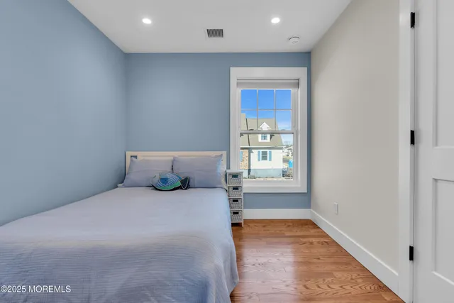 a large bed sitting in a spacious bedroom next to a window
