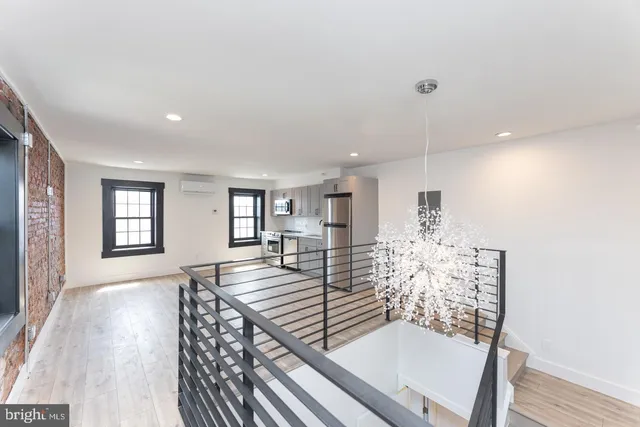 a spacious bedroom with a bed and wooden floor