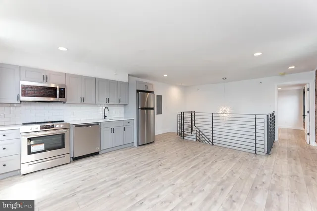 a kitchen with stainless steel appliances a stove a sink and a refrigerator