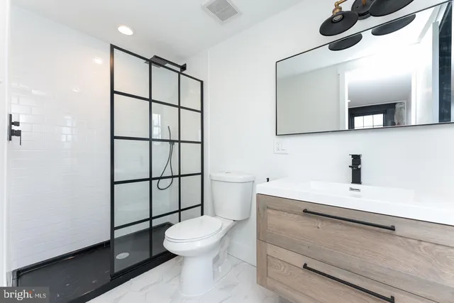 a bathroom with a toilet sink and mirror