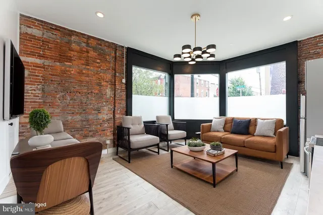 a living room with furniture chandelier and a large window