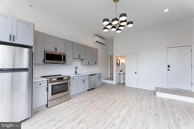 a kitchen with stainless steel appliances a stove top oven a sink dishwasher and a refrigerator