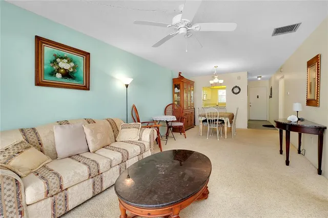 a living room with furniture a chandelier and a painting