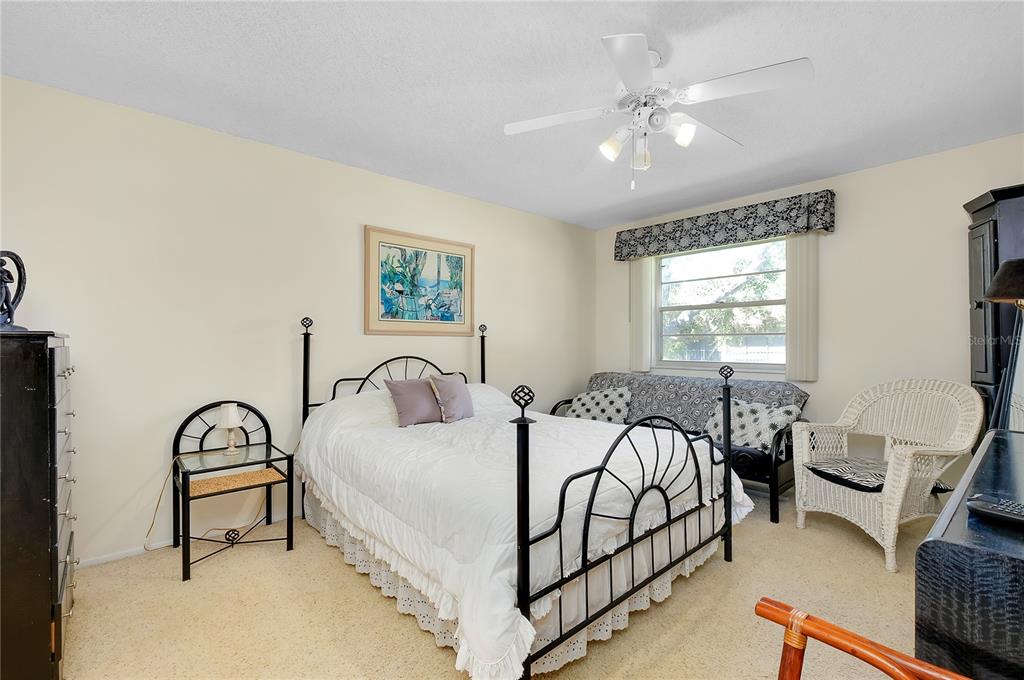 2280 Stickney Point Road, Unit 432 Sarasota, FL 34231 - Photo 16 of 35 a bedroom with a bed and a dresser with mirror