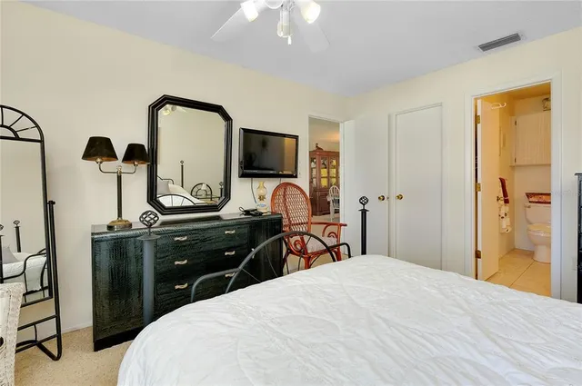 a bedroom with a bed and a flat tv screen on dresser