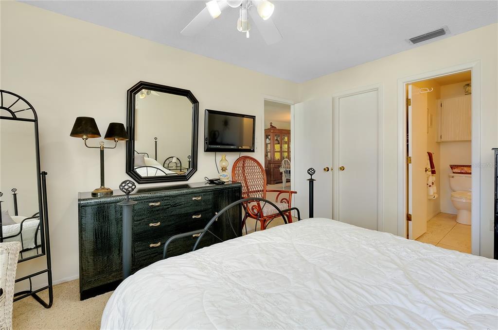 2280 Stickney Point Road, Unit 432 Sarasota, FL 34231 - Photo 18 of 35 a bedroom with a bed and a flat tv screen on dresser