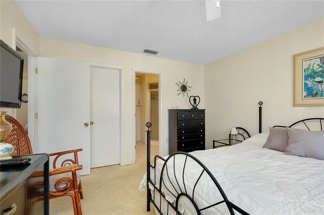 a bedroom with a bed and a flat tv screen on the dresser