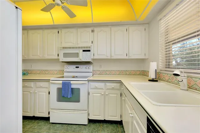 a kitchen with white cabinets and white appliances