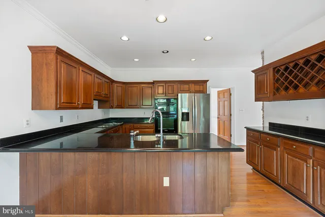 a kitchen with stainless steel appliances granite countertop a sink a stove and a refrigerator