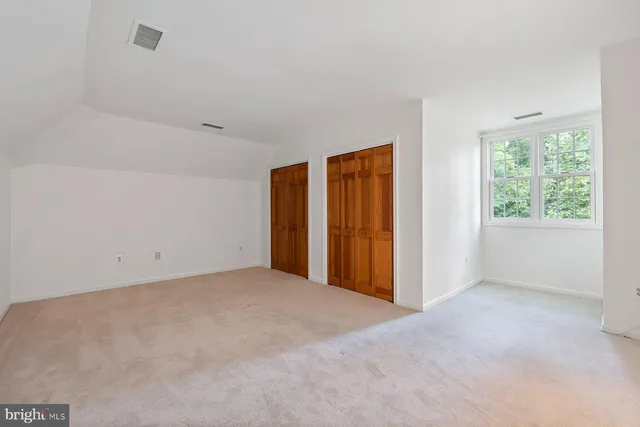 an empty room with a window and a kitchen