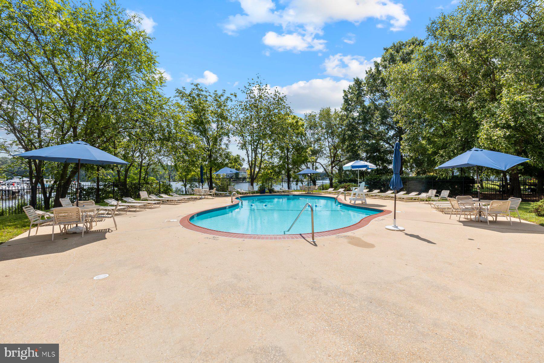 370 South River Landing Road, Unit 370 Edgewater, MD 21037 - Photo 45 of 64 a view of a swimming pool with a table and chairs under an umbrella
