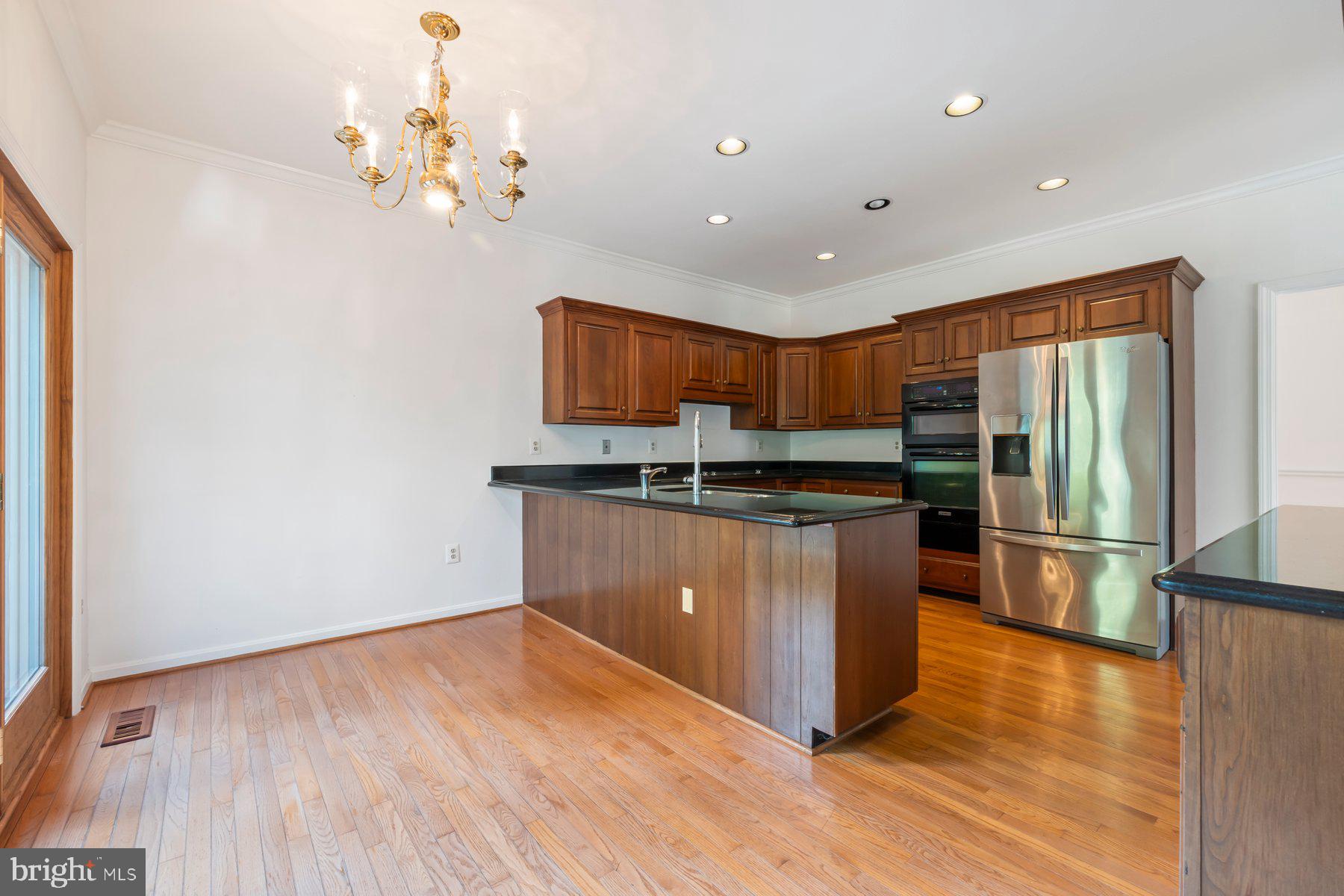 370 South River Landing Road, Unit 370 Edgewater, MD 21037 - Photo 9 of 64 a kitchen with stainless steel appliances granite countertop a refrigerator a sink dishwasher a stove with wooden floor and cabinets