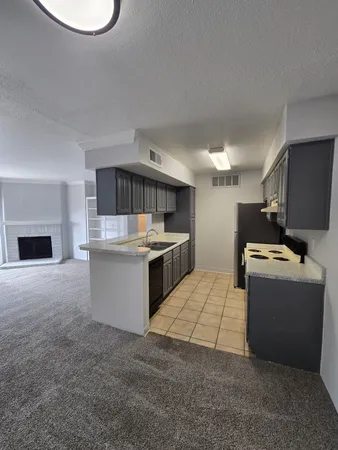 a kitchen with kitchen island granite countertop a sink and a stove top oven