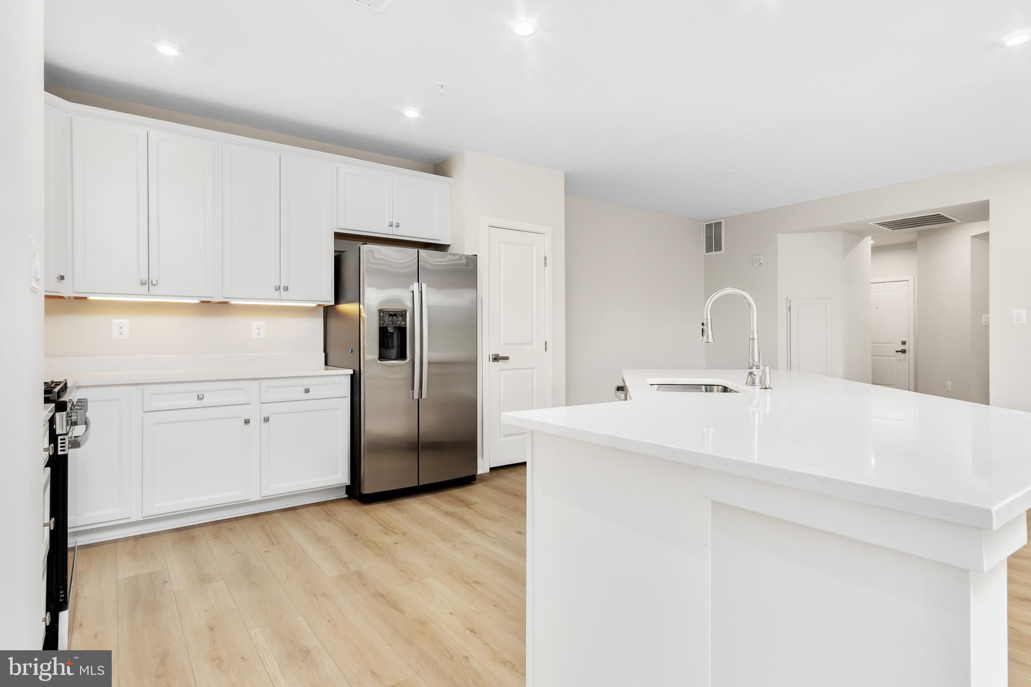9935 Sofield Place, Unit 201 Frederick, MD 21701 - Photo 12 of 39 a kitchen with stainless steel appliances a refrigerator sink and cabinets