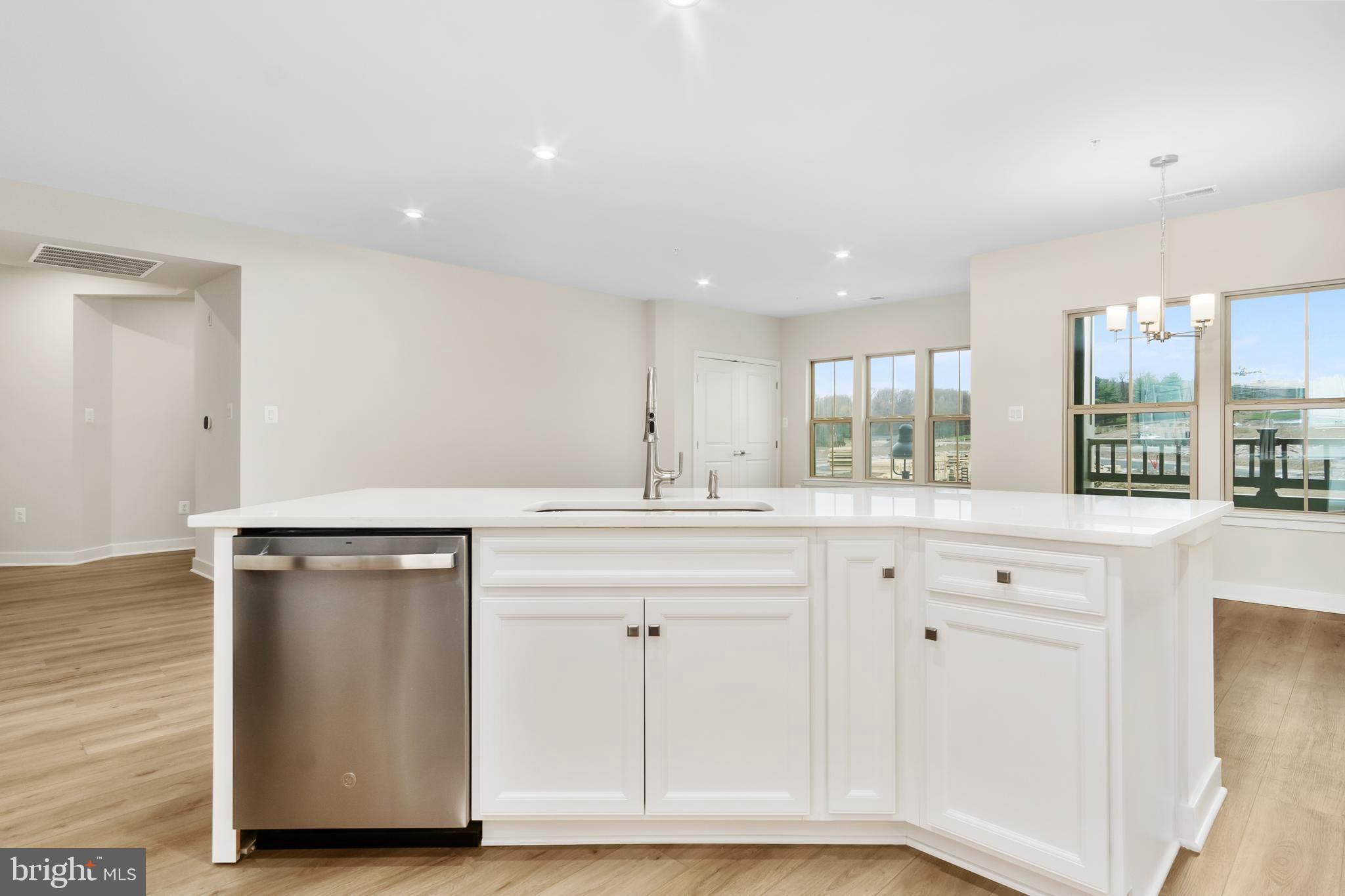 9935 Sofield Place, Unit 201 Frederick, MD 21701 - Photo 15 of 39 a kitchen with granite countertop a sink cabinets and wooden floor