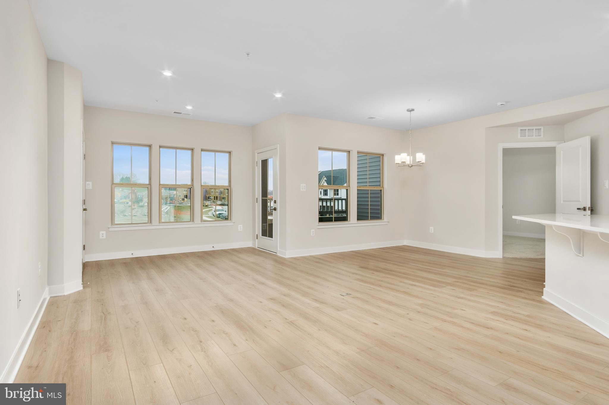 9935 Sofield Place, Unit 201 Frederick, MD 21701 - Photo 18 of 39 a view of an empty room with window and wooden floor
