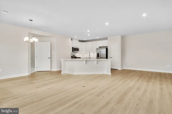 a view of a kitchen with a sink wooden cabinets and a refrigerator