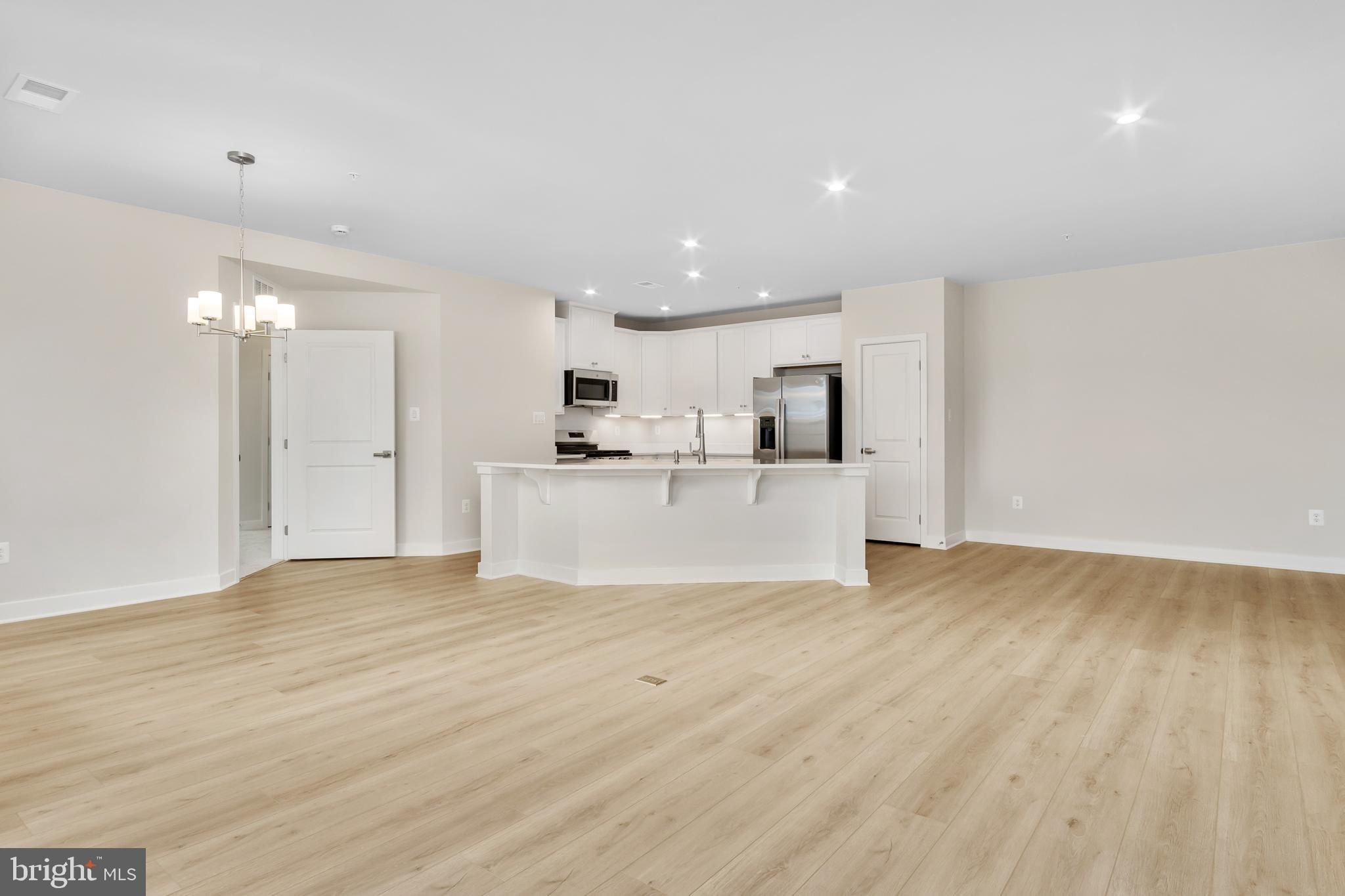 9935 Sofield Place, Unit 201 Frederick, MD 21701 - Photo 22 of 39 a view of a kitchen with a sink wooden cabinets and a refrigerator