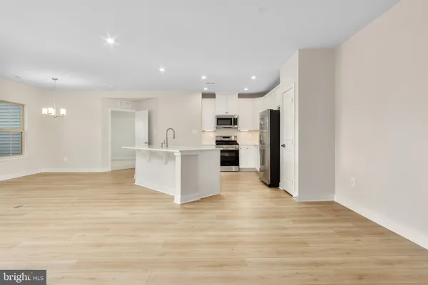 a view of a kitchen with refrigerator and white cabinets