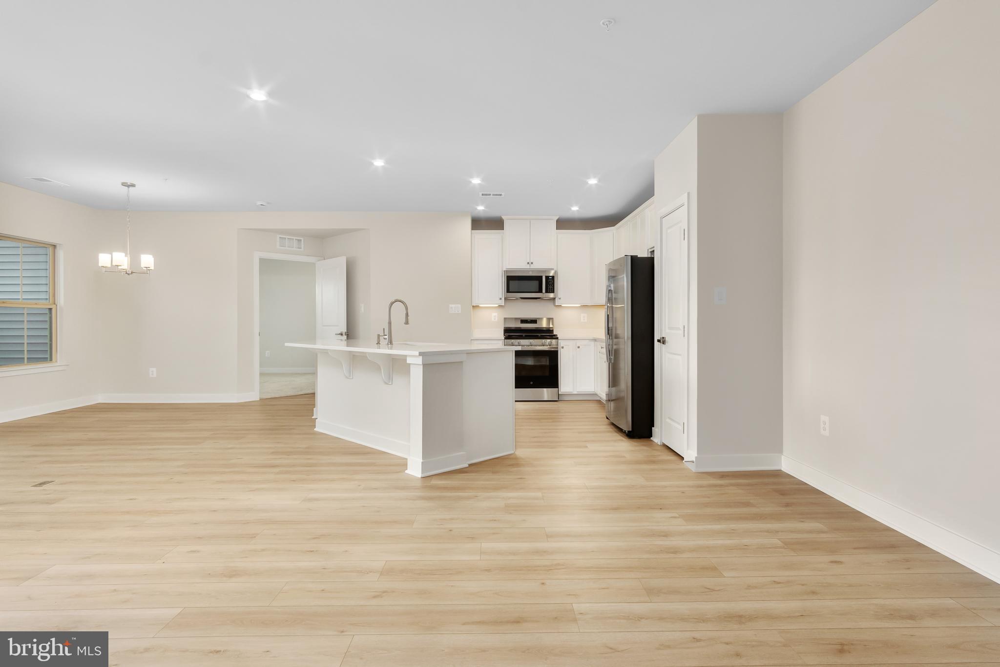 9935 Sofield Place, Unit 201 Frederick, MD 21701 - Photo 8 of 39 a view of a kitchen with refrigerator and white cabinets