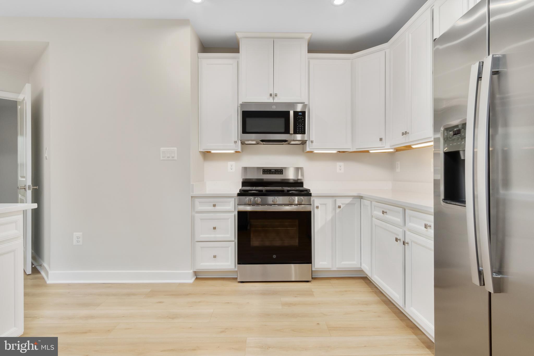 9935 Sofield Place, Unit 201 Frederick, MD 21701 - Photo 9 of 39 a kitchen with white cabinets and stainless steel appliances