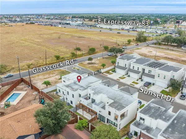 an aerial view of ocean and residential houses with outdoor space