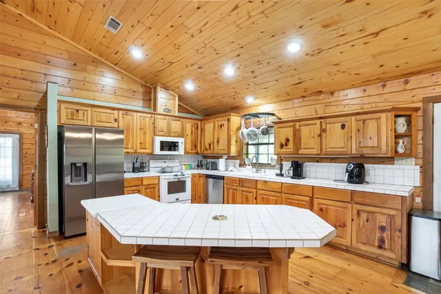 a large kitchen with stainless steel appliances granite countertop a sink and cabinets