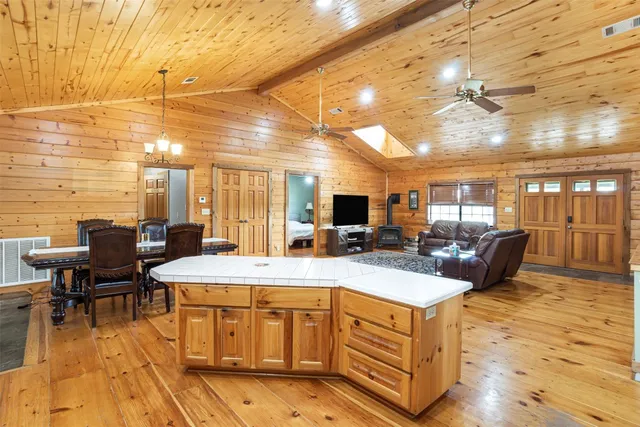 a kitchen with stainless steel appliances kitchen island granite countertop a table chairs and a refrigerator