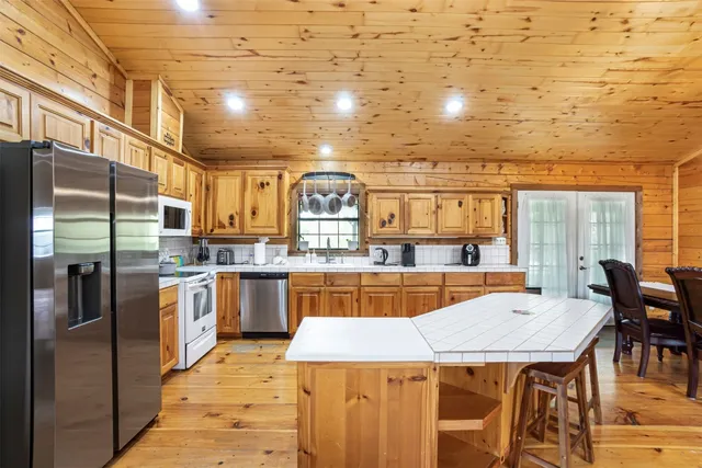 a dining table with chairs and kitchen view