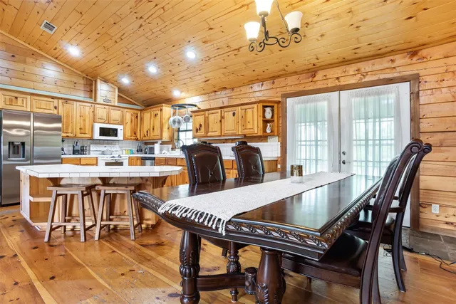 a kitchen with stainless steel appliances dining table and chairs