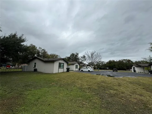a view of a house with a yard and sitting area