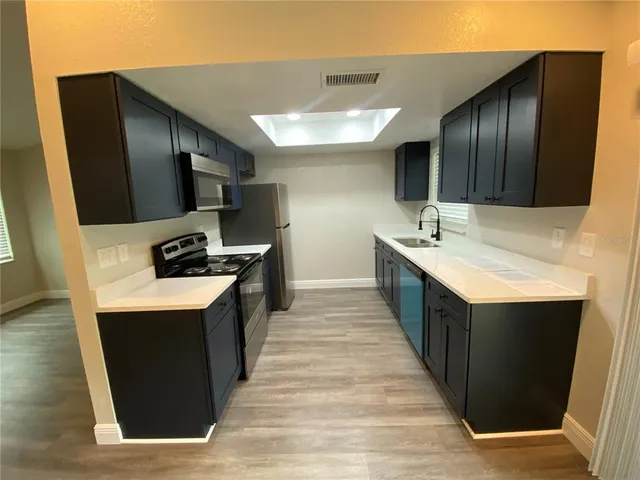 a kitchen with stainless steel appliances a sink stove and refrigerator