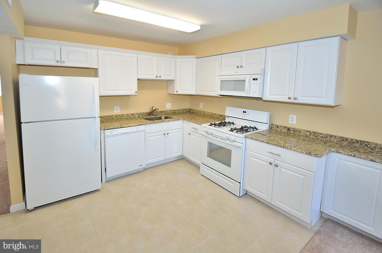 5033 7th Road South, Unit 101 Arlington, VA 22204 - Photo 6 of 13 a kitchen with white cabinets and white appliances