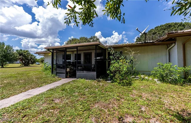 a view of a house with backyard and sitting area