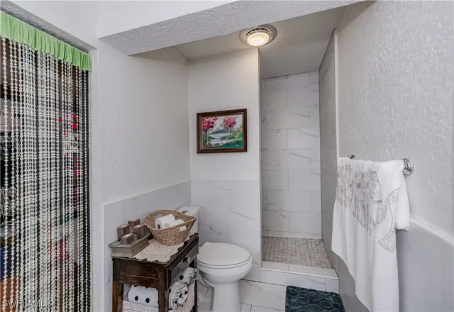 a bathroom with a toilet and a shower curtain