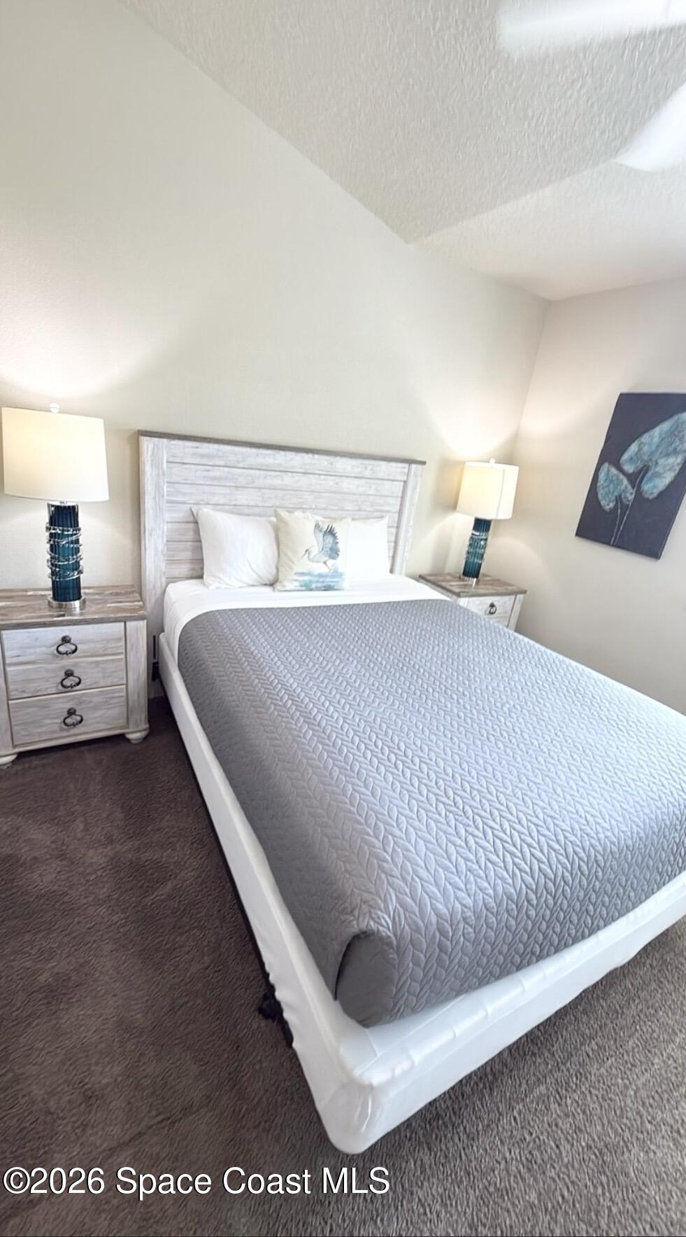 2709 Cutlass Point Lane, Unit 103 Merritt Island, FL 32953 - Photo 15 of 31 a bedroom with a bed and lamp